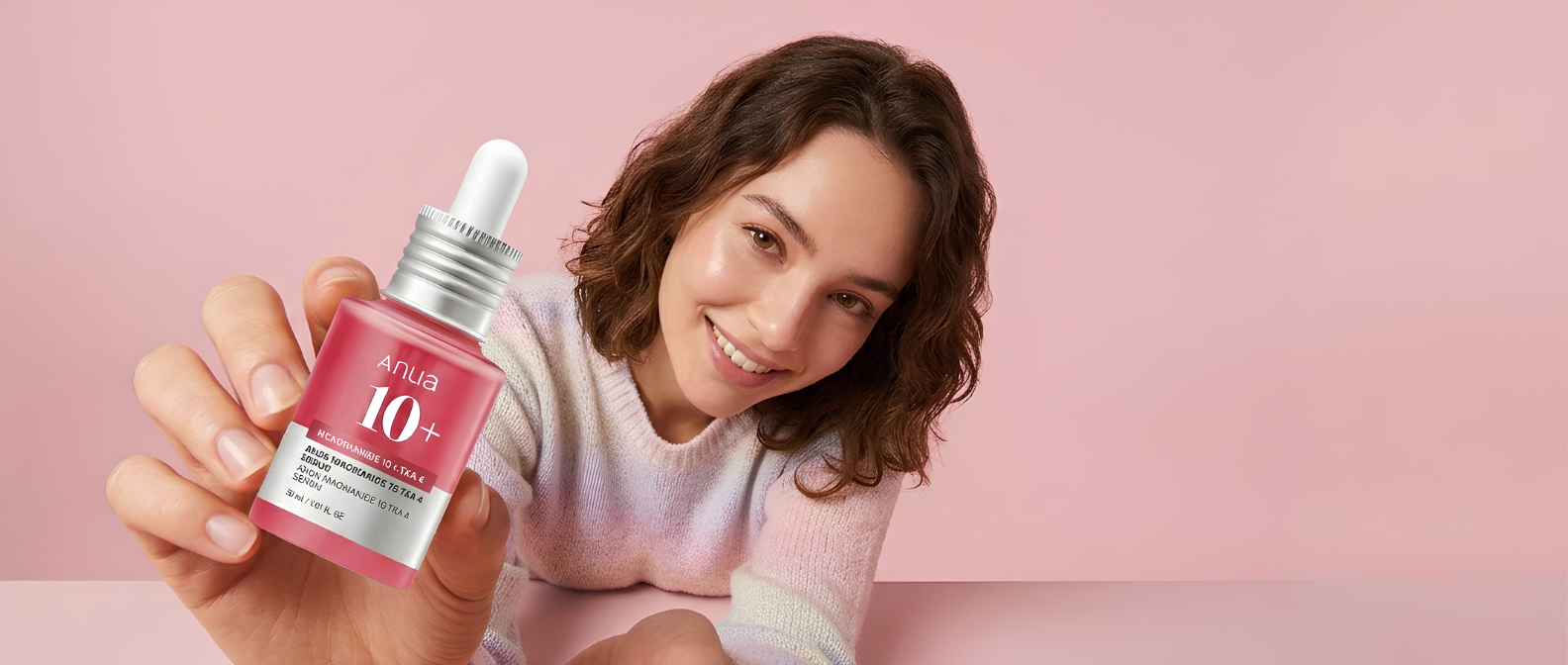 Anua Niacinamide 10 + TXA 4 serum held by a smiling model